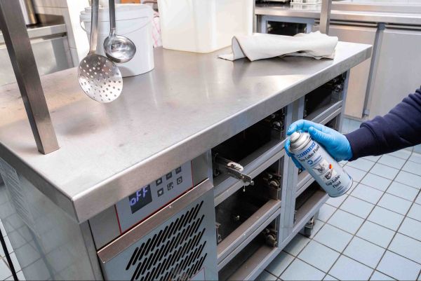 Aplikace spreje na mechanismus zásuvek nerezového gastro zařízení.